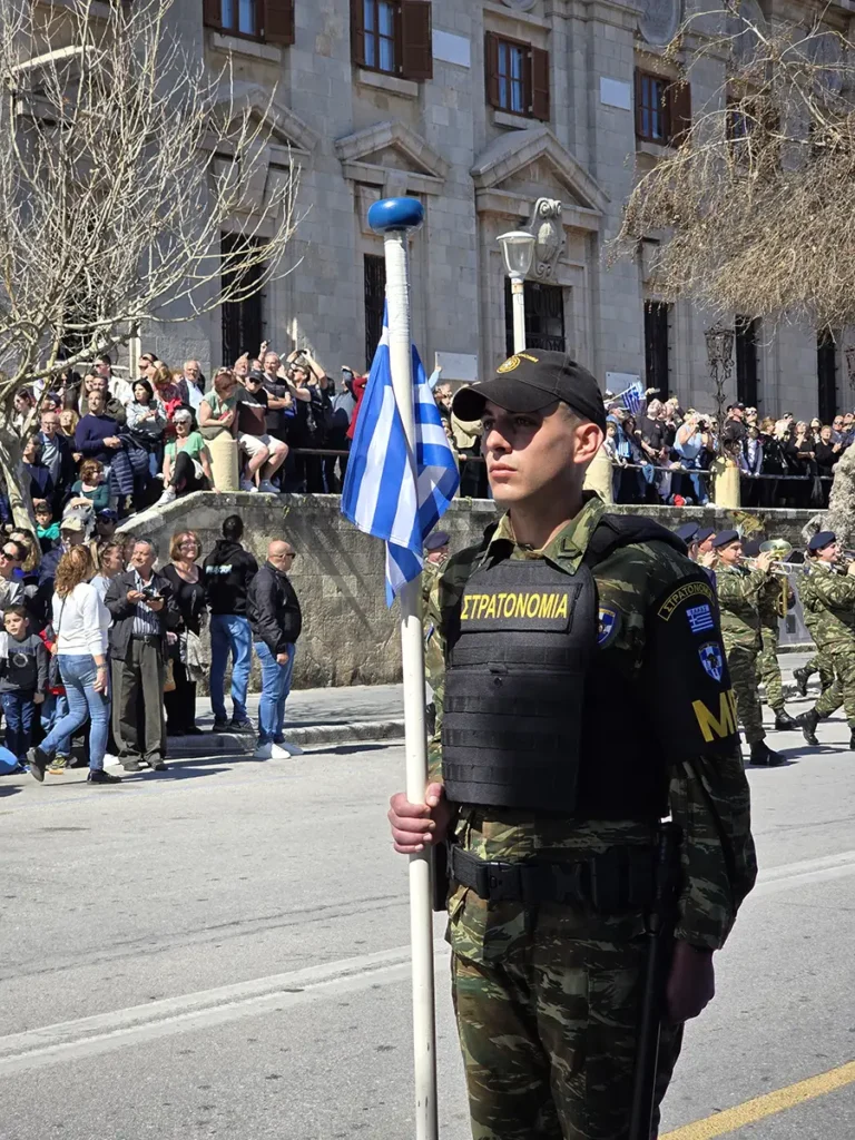 Soldier of Greek Army holding a small Greek flag commemorating March 7 in Rhodes.